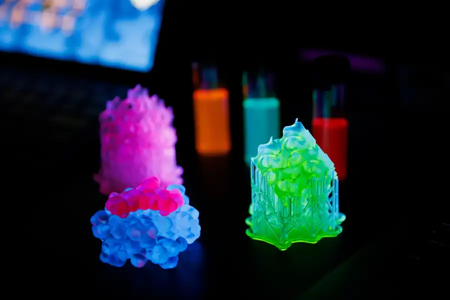 A collection of brightly glowing neon particles on a dark surface.